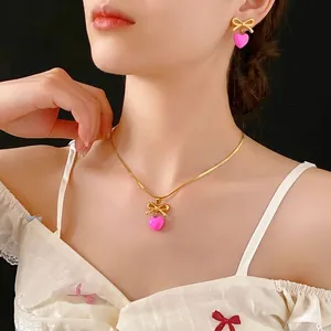 Ensemble collier et boucles d'oreilles en acier doré avec pendentif cœur rose et nœud