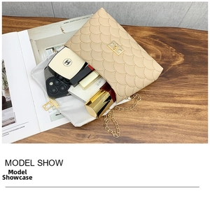 Détail du sac matelassé beige avec fermoir doré sur une table en bois avec des accessoires