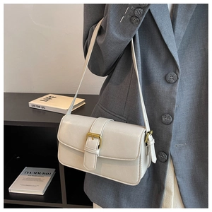 Detail view of cream white wax leather shoulder bag with vintage gold buckle closure