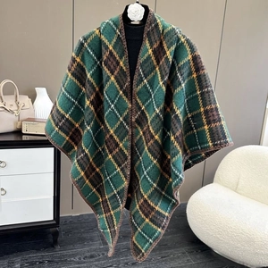 Detail of green plaid poncho scarf with thick knit texture and lock-stitched edges