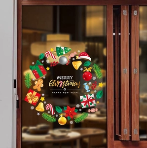 Close-up of a festive Christmas wreath window sticker with gifts and candy on glass