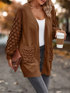 Detailed view of women's coffee knit cardigan with bubble texture sleeves and large pockets