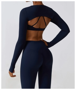 Detailed back view of navy yoga shrug with open back crisscross straps and slim leggings