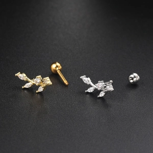 Macro shot of leaf shaped surgical steel ear studs in gold and silver finish with zircon