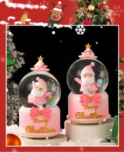 Detailed close-up of pink Christmas Santa snow globe with festive deer design and resin base
