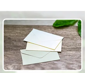 Detailed view of mini triangle envelopes in pearl white, beige and soft green tones