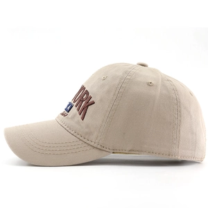 Detail of New York embroidery and USA patch on beige cotton baseball cap side view