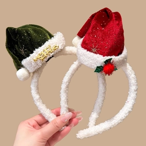Detail of red and green velvet Christmas hat headbands with golden Merry text and stars