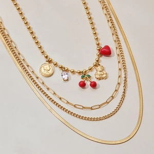 Dettaglio della collana a strati in acciaio 18K con ciondoli a ciliegia e cuore