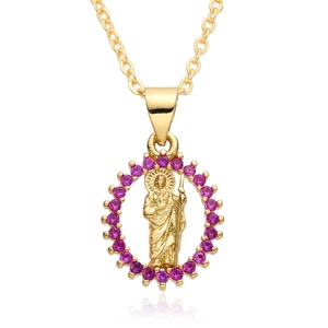 Macro shot of 18k gold plated religious pendant with magenta zircon stones and saint relief