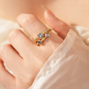 Détail d'une bague vintage dorée avec pierres de zircon sur le doigt d'un mannequin chic