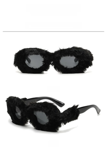 Vue détaillée des lunettes de soleil ovales avec monture en fausse fourrure noire de fête