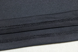 Detailed close-up of double-needle stitching on black functional bodycon dress fabric