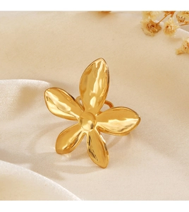 Gros plan détaillé d'une bague fleur en or 18K avec texture martelée sur fond velours