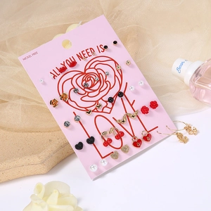 Detail of alloy earring set with cherry, rose, heart, and pearl motifs on display cards
