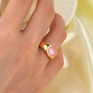 Minimalist 18K gold stainless steel ring with pink heart pattern on a finger
