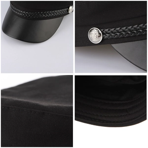 Detail view of black baker boy hat with silver crest button and braided strap trim