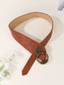 Close-up of brown leather belt with floral embossing and bronze rivet studs decoration