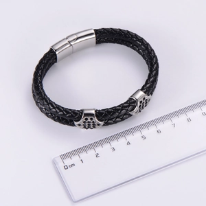 Dettaglio del bracciale doppio in pelle nera intrecciata con chiusura magnetica argento e zirconi