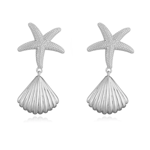 Macro detail of silver starfish and seashell drop earrings with textured metal finish