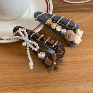 Detailaufnahme von Haarspangen mit Leopardenmuster, Perlen, Strass und Wollstoff