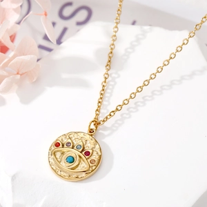 Gros plan du pendentif œil porte-bonheur doré avec strass colorés et turquoise
