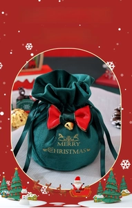 Detail of dark green velvet Christmas gift bag with golden reindeer and red bow