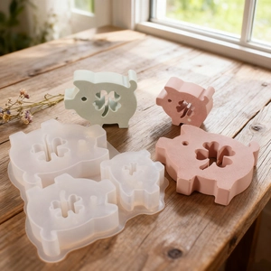Macro detail of cartoon pig silicone mold and finished resin crafts with clover pattern