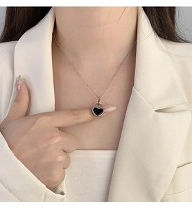 Detailed view of an S925 silver necklace featuring a black heart-shaped lock pendant