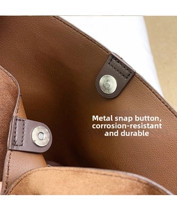 Close-up of durable magnetic hardware snaps on a brown pebble grain tote bag interior