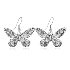 Boucles d'oreilles papillon vintage en argent texturé avec crochets sur fond blanc neutre