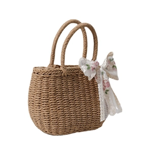 Brown woven straw handbag with floral lace ribbon detail on white background