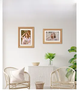 Detailed view of two wooden photo frames with subtle horizontal grain on a white sideboard