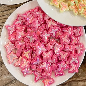 Close-up of pink and yellow pearlescent butterfly beads for DIY jewelry making