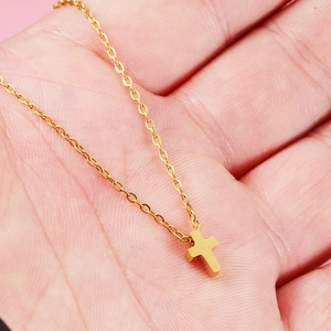 Minimalist gold stainless steel cross necklace featuring a sleek polished finish