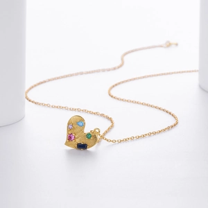 Elegant gold heart pendant necklace featuring textured surface and multi-colored gemstones