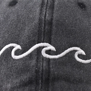 Washed cotton baseball cap with unique white wave embroidery and vintage distressed finish