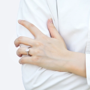 Close-up of 925 sterling silver ring with oval zircon main stone on a model's finger
