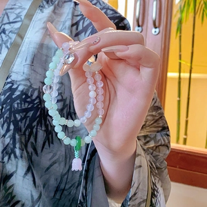 Detail of beaded bracelets with lily of the valley pendants and translucent pink and green beads