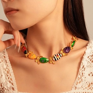 Close-up of colorful enamel egg pendants with golden bowknot details on model's neck