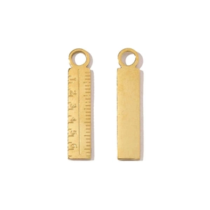 Macro shot of gold stainless steel ruler pendant with numeric scales 1 to 6 for DIY jewelry