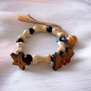 Detail of macaron ceramic bead bracelet with bone charms, star pendant and colorful tassels