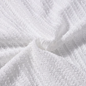 Gros plan du tissu rayé blanc avec texture en relief et détails de volants sur la robe