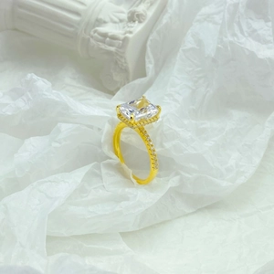 Close-up of a gold S925 silver ring with a square ice-cut stone and side diamonds