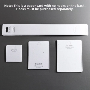 Macro detail of white S925 silver jewelry display cards set on a gray textured surface