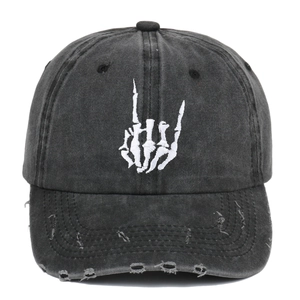 Distressed black cotton baseball cap with skull gesture embroidery and worn hole details
