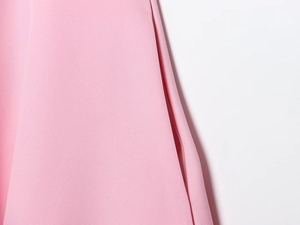 Detail of delicate side seam and hidden pocket on a pink backless halter neck dress