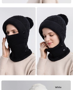 Dettaglio del set cappello e sciarpa in maglia con pompon in pelliccia sintetica nero e bianco