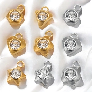 Assorted gold and silver stainless steel pendants with sparkling cubic zirconia on white silk