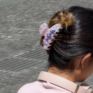 Pink marble acetate hair claw clip with Mama lettering on woman's updo hairstyle